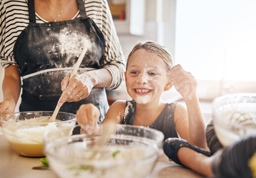 Mom, playing or happy girl baking in kitchen as a happy family with a playful young kid with flour at home. Dirty, messy or mom helping, cooking or teaching fun daughter to bake for child development