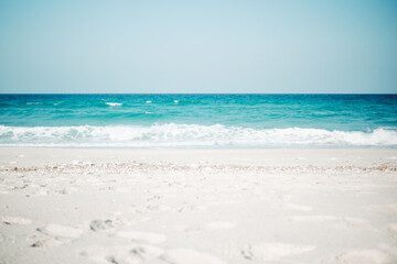 Pristine sandy beach with turquoise waters and mountain backdrop at Delisha, Socotra, Yemen.