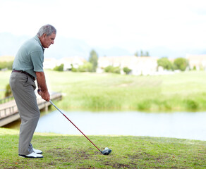 Fototapeta premium Senior, man or golfer playing golf for fitness, workout or exercise with a swing on a green course. Stroke, person golfing or mature player training in sports game driving with a club in retirement