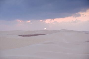 Sunset over the expansive Zahek Dunes in Socotra, Yemen, with the sun sinking below the horizon.