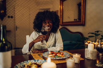 Fototapeta na wymiar Portrait of an african american woman having a romantic date at home with her boyfriend