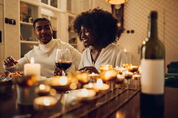 African american couple having romantic date and drinking wine at home