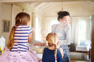 Mom, playing or children baking in kitchen with messy kids siblings smiling with flour on dirty clothes at home. Smile, happy or parent cooking or teaching fun daughters to bake for child development
