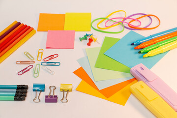 Colorful papers, markers, pencils and hooks for school.