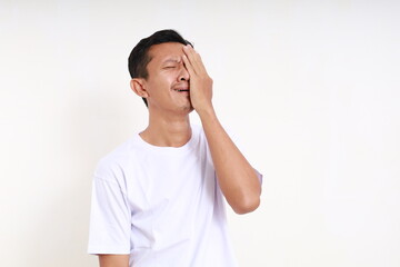 Asian man crying frustrating while covering his face. Isolated on white background