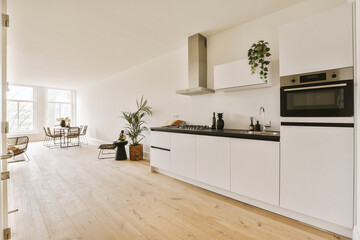 a kitchen with white cabinets and black counter tops on the island in front of the sink is an open door that leads to a