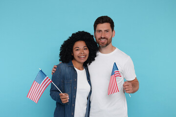 4th of July - Independence Day of USA. Happy couple with American flags on light blue background