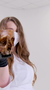 Occult with a skull. The woman moves her hands over the skull and burning candles. High quality 4k footage