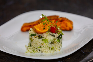 Chic plate of grilled salmon with broccoli rice garnished with fine herbs. real food