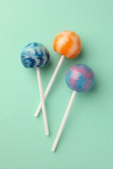 Tasty lollipops on turquoise background, flat lay