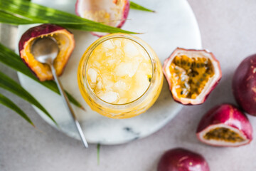 Glass of Iced passion fruit soda with lemon and passion fruit half slice on a light background,...