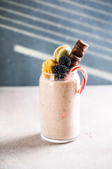 Chocolate indulgent extreme milkshake with macaroons, berry  and sweets. Crazy freakshake food trend. Copy space