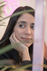 adorable latino young woman with straight hair and as decoration a natural plant, beauty and nature indoors, portrait