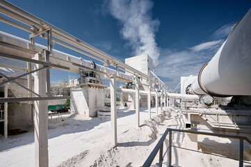 Long tubular rotary furnace at silica factory on sunny day