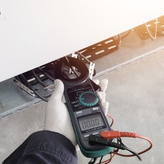 Checking and measuring power cable lines in solar panel. With shiny light.