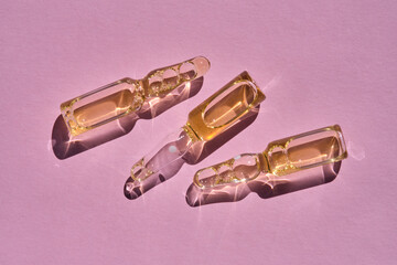 Ampoules on a pink background on the sun.