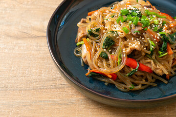 japchae or stir-fried Korean vermicelli noodles with vegetables and pork topped with white sesame