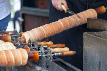 Baker cuting out a Trdelník freshly made