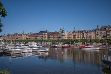 Bay view at Ladugårdslandsviken, jetty wit new boats, old boats and apartment house at the pier...