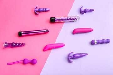 Vibrators with anal plugs on color background