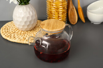 Teapot with cups and different kitchen stuff on black table