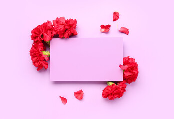 Red carnations and blank card on lilac background
