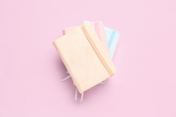Stack of notebooks on pink background