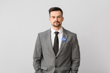 Male volunteer with badge on light background