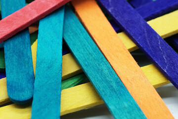 A close-up of Coloured Wooden Paddle Pop sticks used in craft and Child playing
