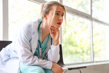 Sad female doctor sitting in clinic