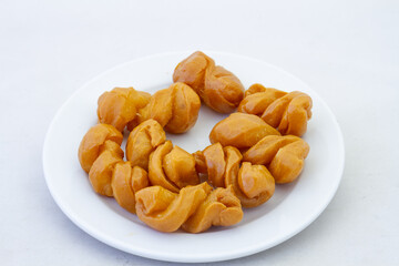 A plate of traditional South African koeksisters isolated on a clear background with copy space