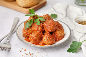 Plate of tasty meat balls with sauce on light background