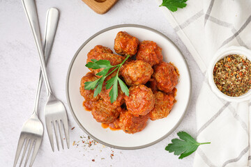 Plate of tasty meat balls with sauce on light background
