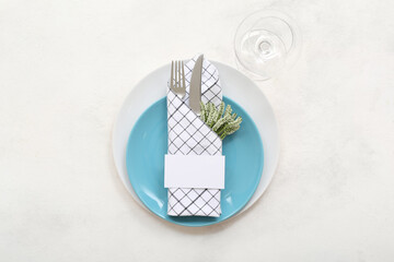 Table setting with clean plates, cutlery and floral decor on white grunge table
