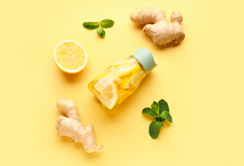 Sports bottle of infused water with lemon and ginger on yellow background