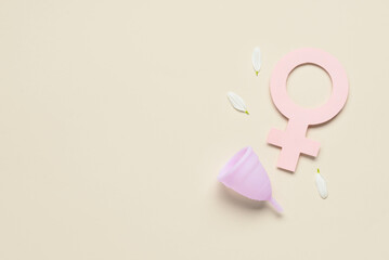 Composition with menstrual cup and woman symbol made of paper on beige background