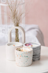 Holders with candles on table in light room, closeup