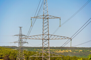 High voltage towers with sky background. Power line support with wires for electricity transmission. High voltage grid tower with wire cable at distribution station. Energy industry, energy saving