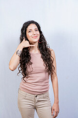 Naklejka premium Young woman making phone gesture with fingers. Young girl making phone gesture isolated, Concept of people making phone gesture on white background