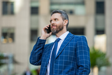 businessman call on phone and talk. businessman has phone call outdoor. businessman having phone call in the street. businessman call on phone outside