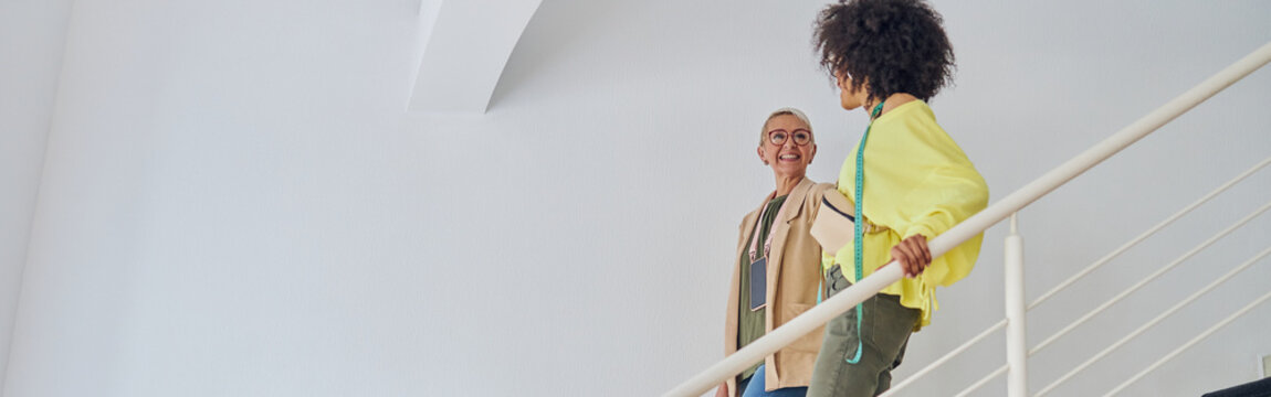 African-American woman with smiling mature colleague fashion des
