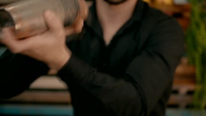 A bartender makes a cocktail in a shaker. High quality FullHD footage