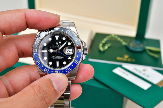 Bangkok Thailand- June 24,2023: Hand holding Rolex GMT-Master II "Batman"40mm with blue-black bezel Steel Ceramic Men's Wrist watch 