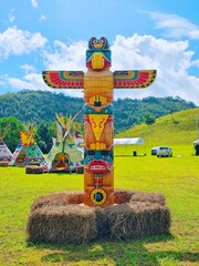 Wooden totem pole isolated in mountain blue background, American indian totem pole in Thailand,...