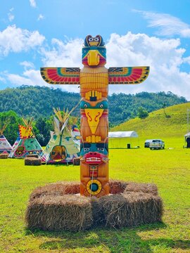 Wooden totem pole isolated in mountain blue background, American indian totem pole in Thailand, June 23, 2023