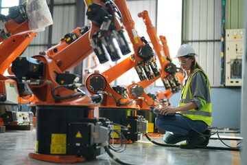 Portrait of Female Automotive Industry 4.0 Engineer in Safety Uniform Using Laptop at Car Factory...