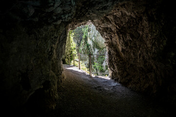 Beautiful tunnel leading through the steep, rocky cliffs of Soca river canyon, popular tourist...