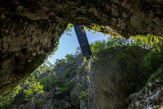 Wooden bridge, suspended high above Soca river canyon on the steep, rocky slopes of slovenian Alps