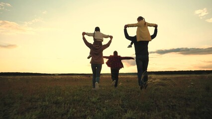 happy family jogging at sunset. group people child mother father run glare sun. family outdoors...