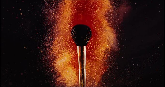 Make up brush and colored powder, particles exploding. Shot with high speed camera. Slow Motion.